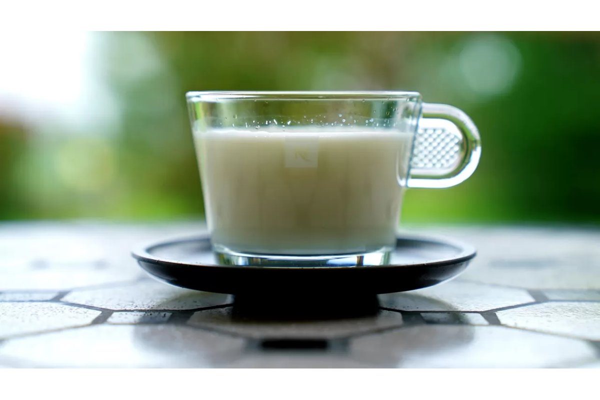 Persona che beve un bicchiere di latte caldo prima di dormire.