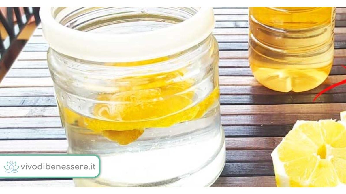 Bucce di limone e aceto in una ciotola vicino a un piano cottura sporco.