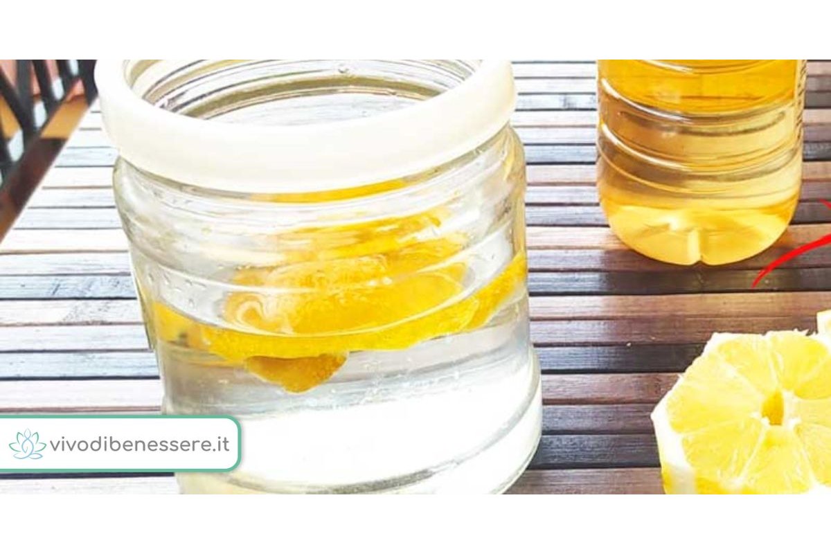 Bucce di limone e aceto in una ciotola vicino a un piano cottura sporco.